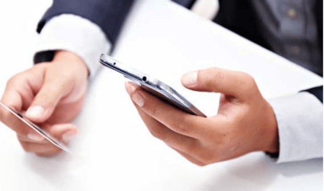 Personne en costume avec smartphone, carte de crédit.